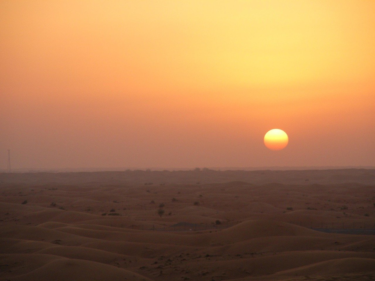 Dune buggy riding at sunset in Dubai desert with clear skies