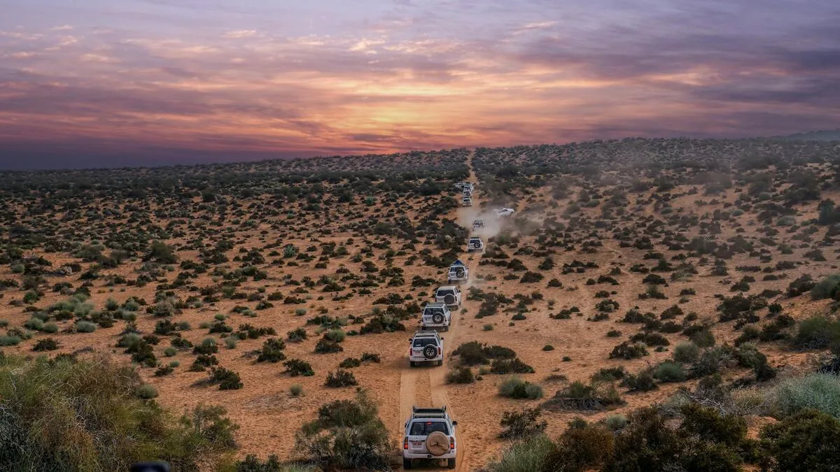 Evening desert safari Dubai with vibrant orange sky at sunset over Lahbab dunes